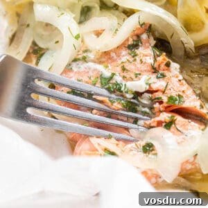 Steamed Salmon with Fresh Herbs and Lemon: Quick Flavorful Recipe 13 A filet of salmon being cut with a fork and fresh lemon slices.