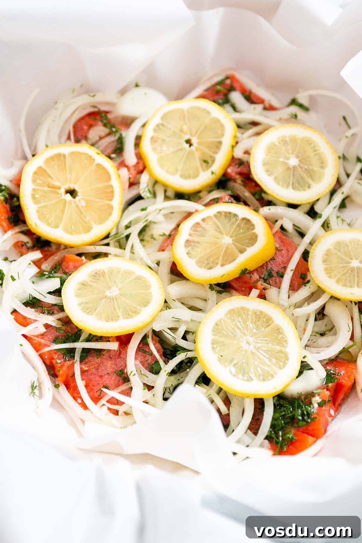 Steamed Salmon with Fresh Herbs and Lemon: Quick Flavorful Recipe 6 Parchment paper with salmon, onions and lemons slices.