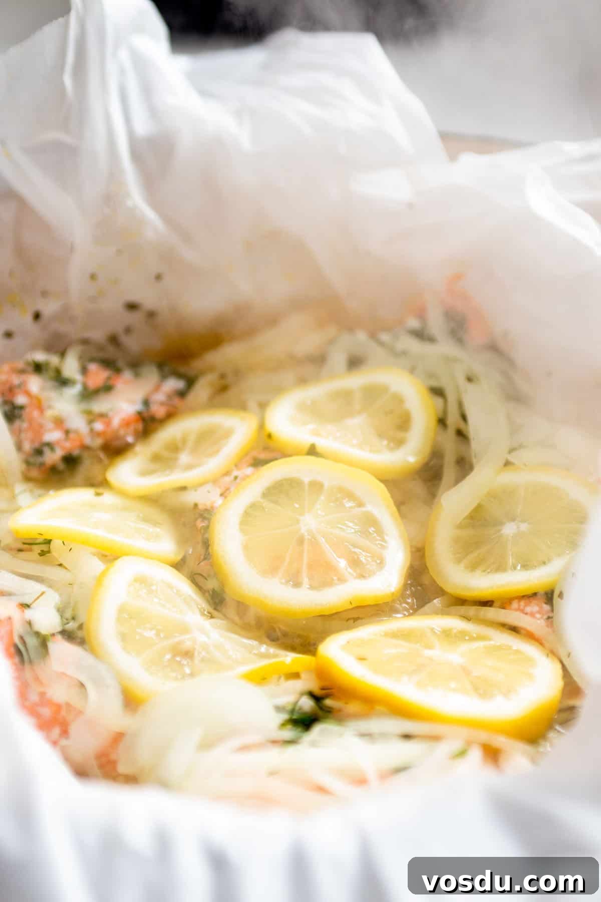 Steamed Salmon with Fresh Herbs and Lemon: Quick Flavorful Recipe 8 Parchment paper with steamed salmon and sliced lemons.
