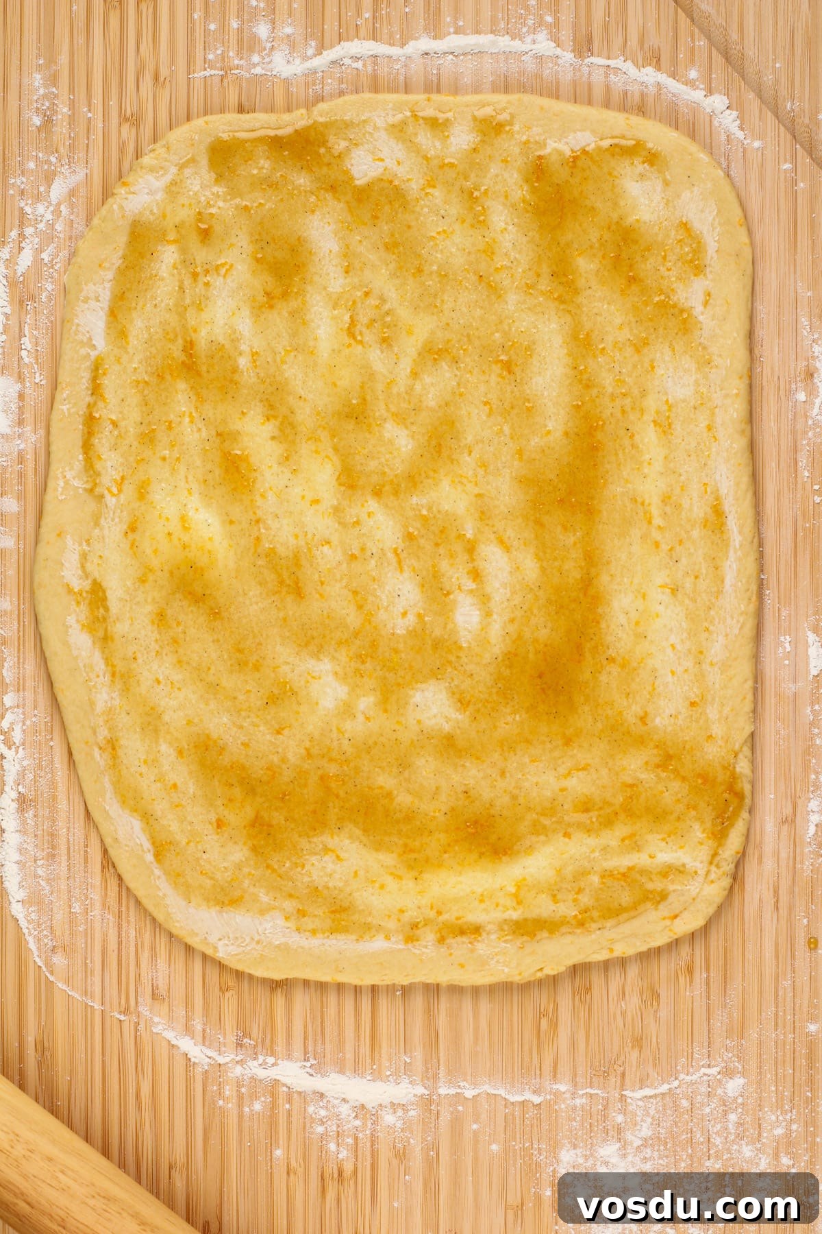 Rolled out dough topped with softened butter and sticky orange filling.