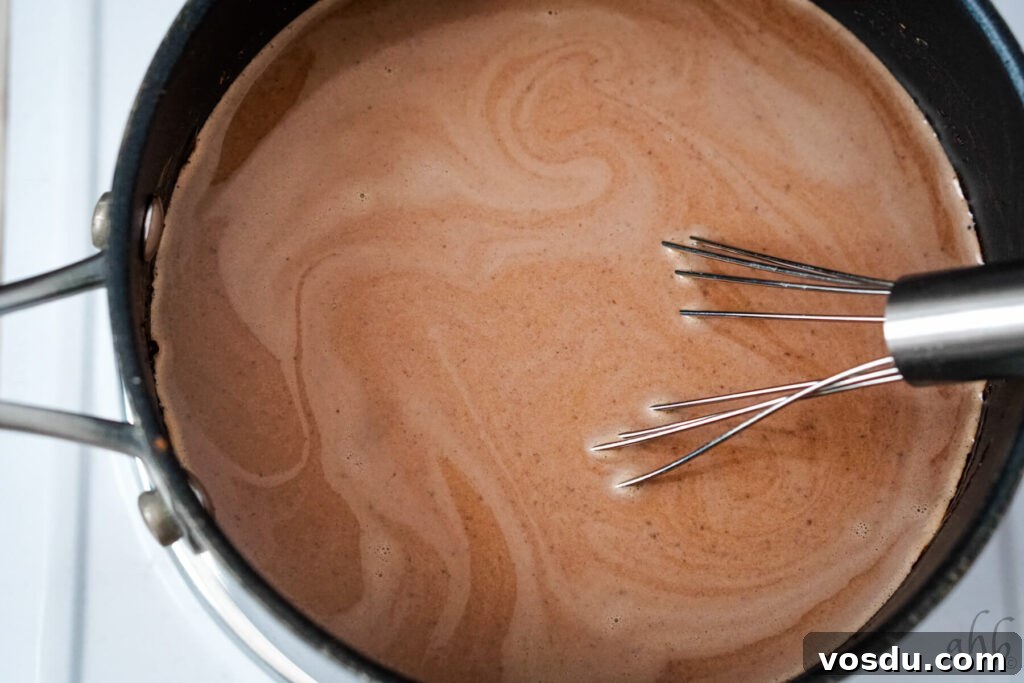 Velvety Orange Hot Chocolate Recipe: Creamy Spiced Cocoa 9 Orange extract being added to the hot chocolate.