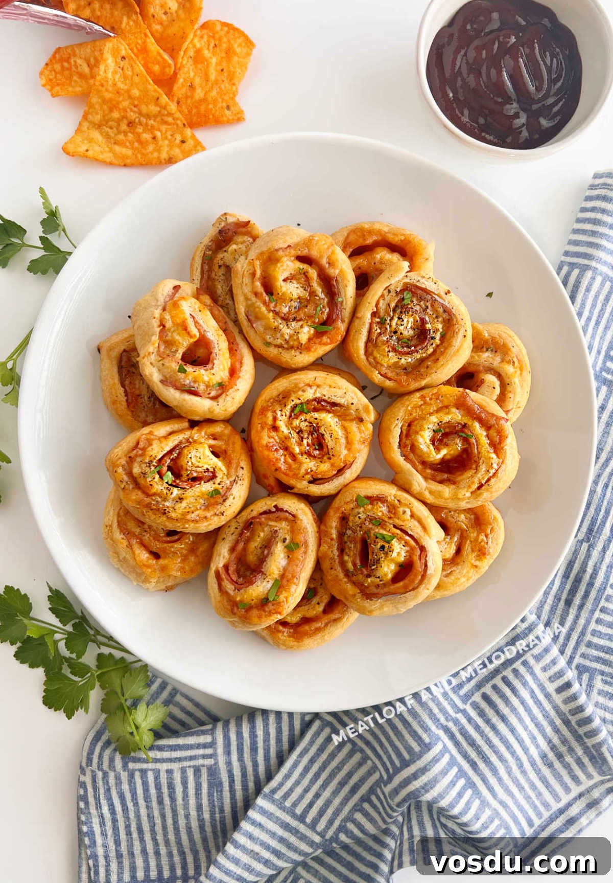 Ham and Cheese Crescent Roll-Ups Baked to Golden Perfection 2 baked ham and cheese crescent rolls with parsley on the table