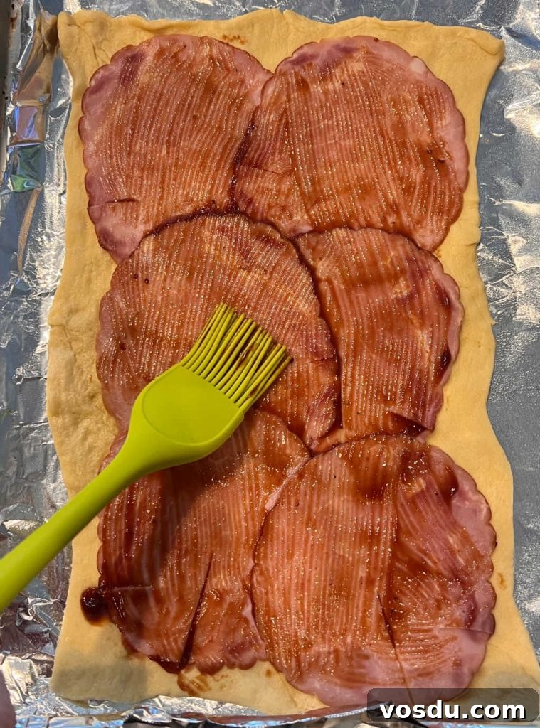 Ham and Cheese Crescent Roll-Ups Baked to Golden Perfection 4 rolled out crescent dough with ham slices and bbq sauce