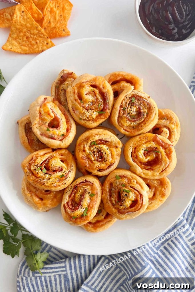 Ham and Cheese Crescent Roll-Ups Baked to Golden Perfection 6 plate of baked ham and cheese rolls on the table