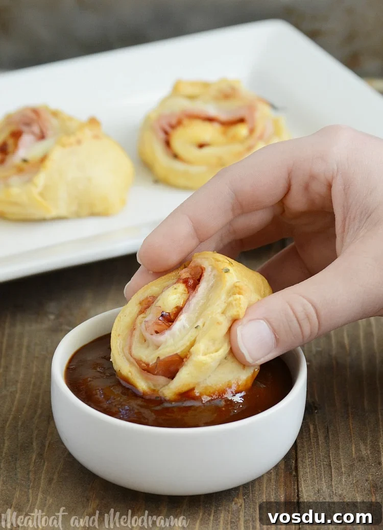 Ham and Cheese Crescent Roll-Ups Baked to Golden Perfection 7 dipping roll ups into barbecue sauce