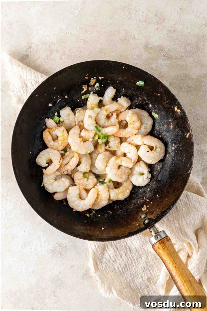Prawn and Egg Fried Rice Recipe — Quick Weeknight Meal 7 Cooking prawns in a wok.
