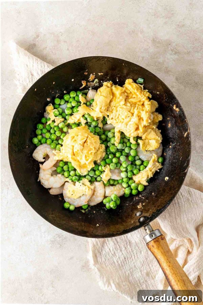 Prawn and Egg Fried Rice Recipe — Quick Weeknight Meal 8 Prawns, peas and eggs in a wok.