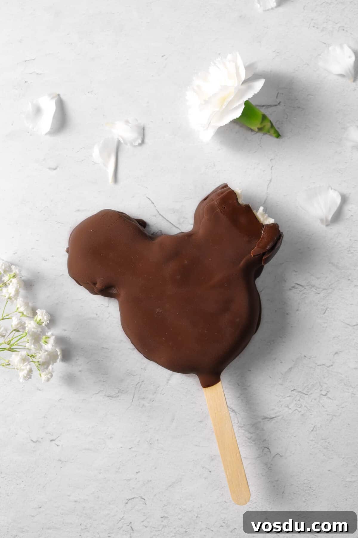Mickey Mouse Ice Cream Bars: Where to Buy & Nutrition Facts 14 mickey bar with a bite taken out of the ear with flowers