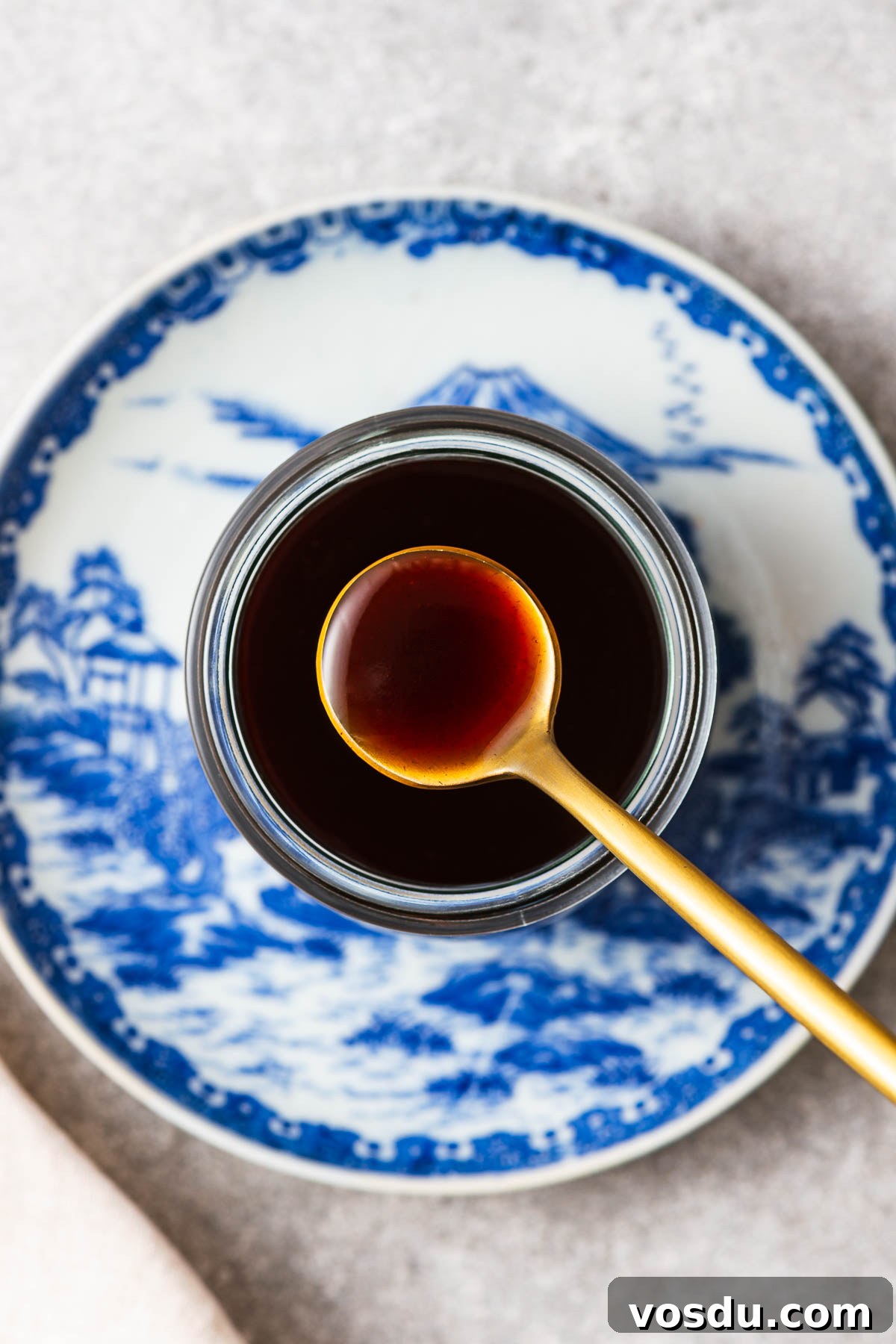 Homemade Yakisoba Sauce: Authentic Japanese Noodle Sauce Recipe 2 A spoon of yakisoba sauce from a glass jar placed on Japanese crockery.