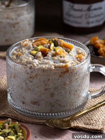 Eye-level view of creamy apricot oatmeal in a wood surface.