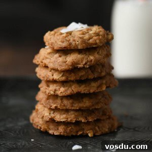 Chewy Coconut Oatmeal Cookies with Toasted Coconut 14 Close-up of coconut oatmeal cookies stacked with milk in the background.