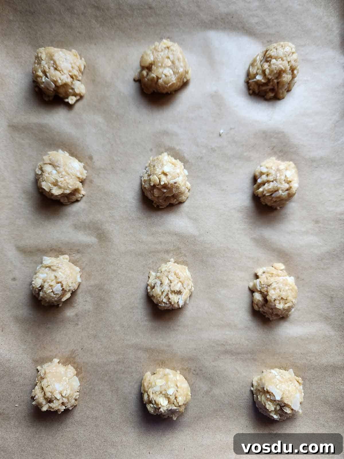 Chewy Coconut Oatmeal Cookies with Toasted Coconut 6 Cookie batter dropped on a parchment lined baking sheet.