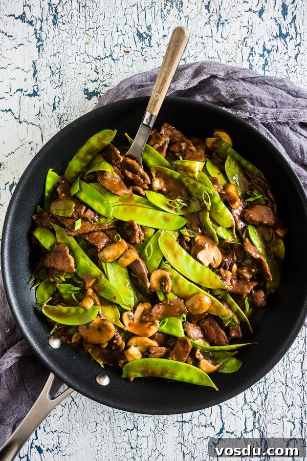 Beef Snow Pea Skillet in a skillet with a spoon. 