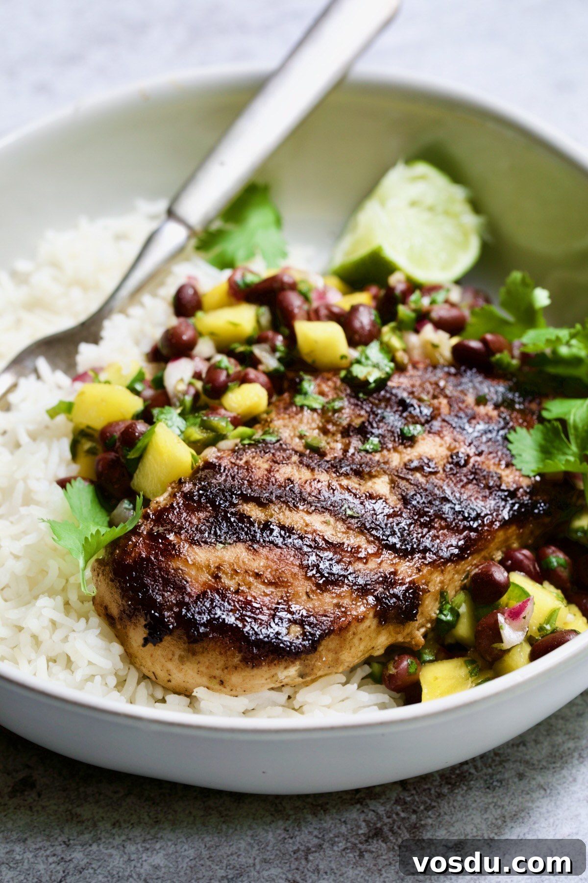 Caribbean Chicken with Black Bean and Mango Salsa Recipe 3 Caribbean Jerk Chicken with Mango Black Bean Salsa with rice in white bowl.