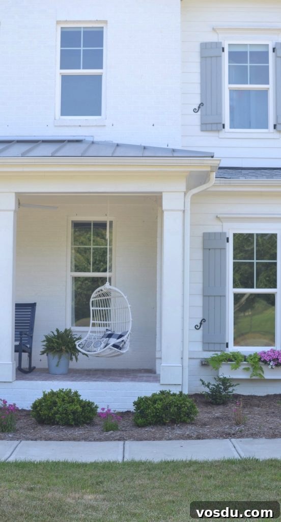 9 Stylish Hanging Rattan Chairs You’ll Love 13 white hanging outdoor chair on a porch