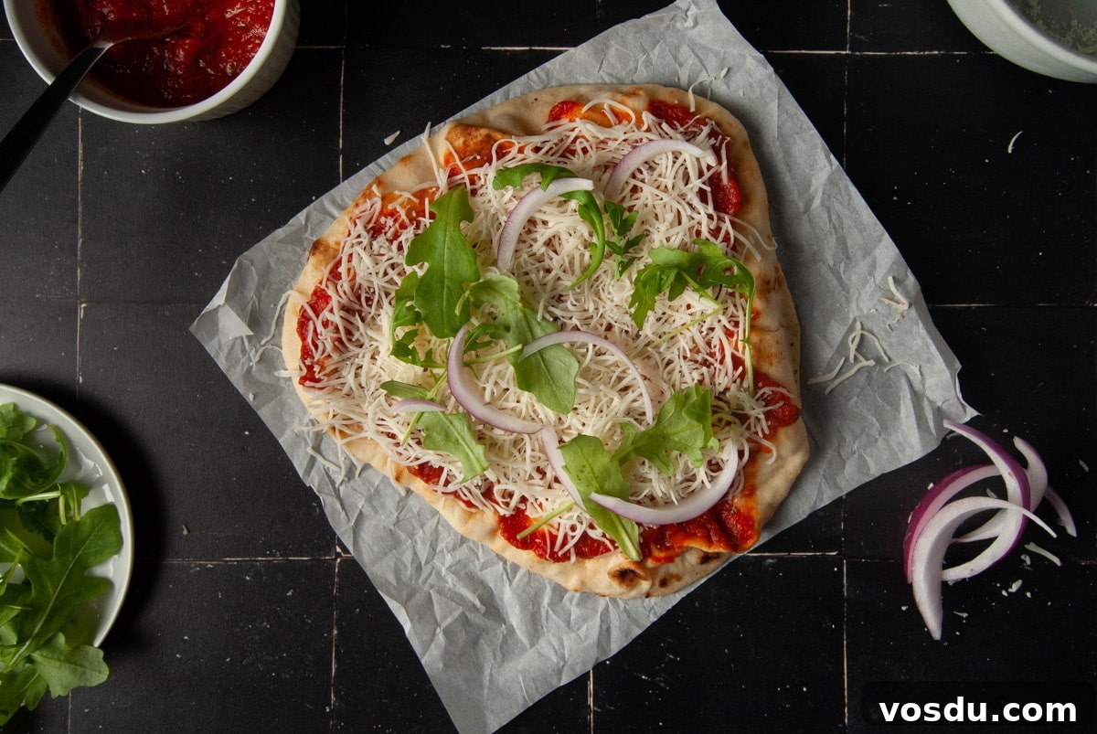 15-Minute Vegetarian Naan Breakfast Pizza Recipe 5 Adding red onion and arugula to breakfast pizza.
