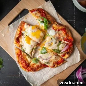 Naan pizza with an egg on top, sliced so that the yolk is running.
