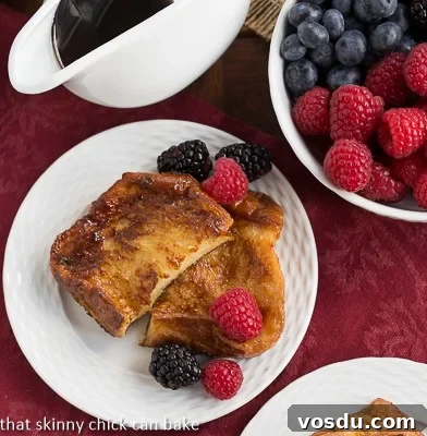 Sugar-Crusted French Toast - a double coating of sugar make this rich, eggy French toast dessert worthy! Overhead view of Sugar-Crusted French Toast on a white ceramic plate with fresh berries.