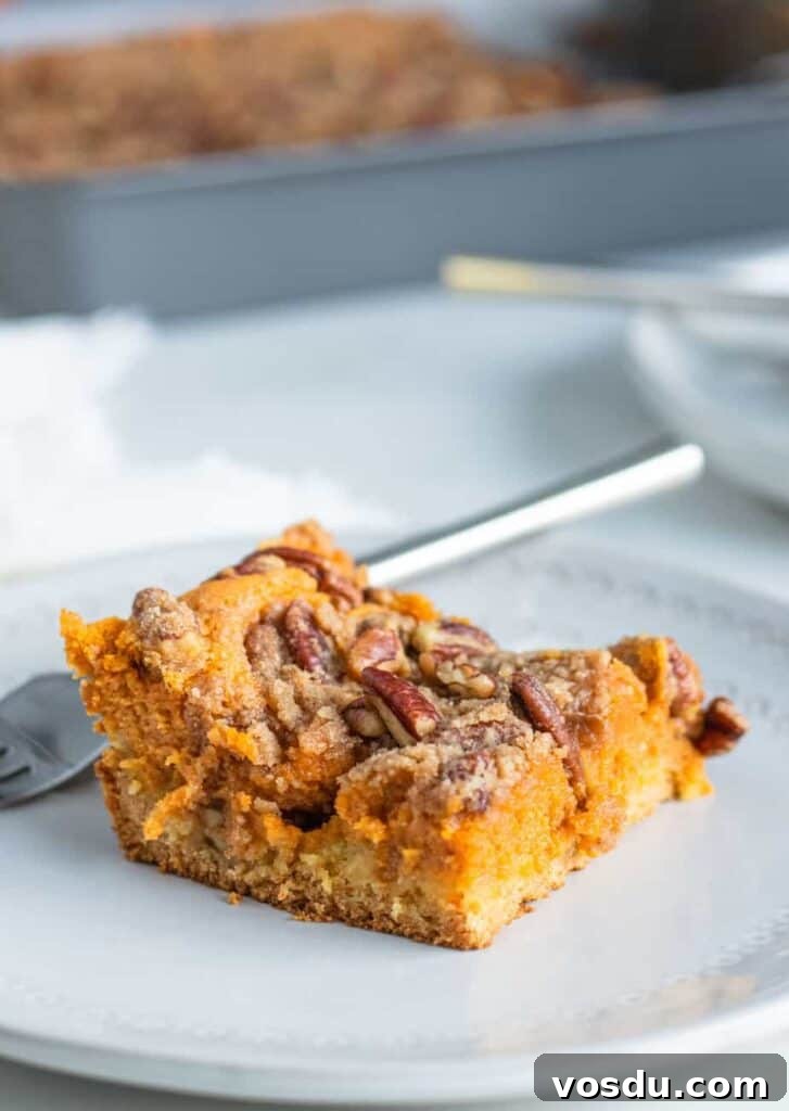 Pumpkin Gooey Butter Cake with Pecan Streusel Recipe 5 close up of gooey butter cake on a plate with a fork
