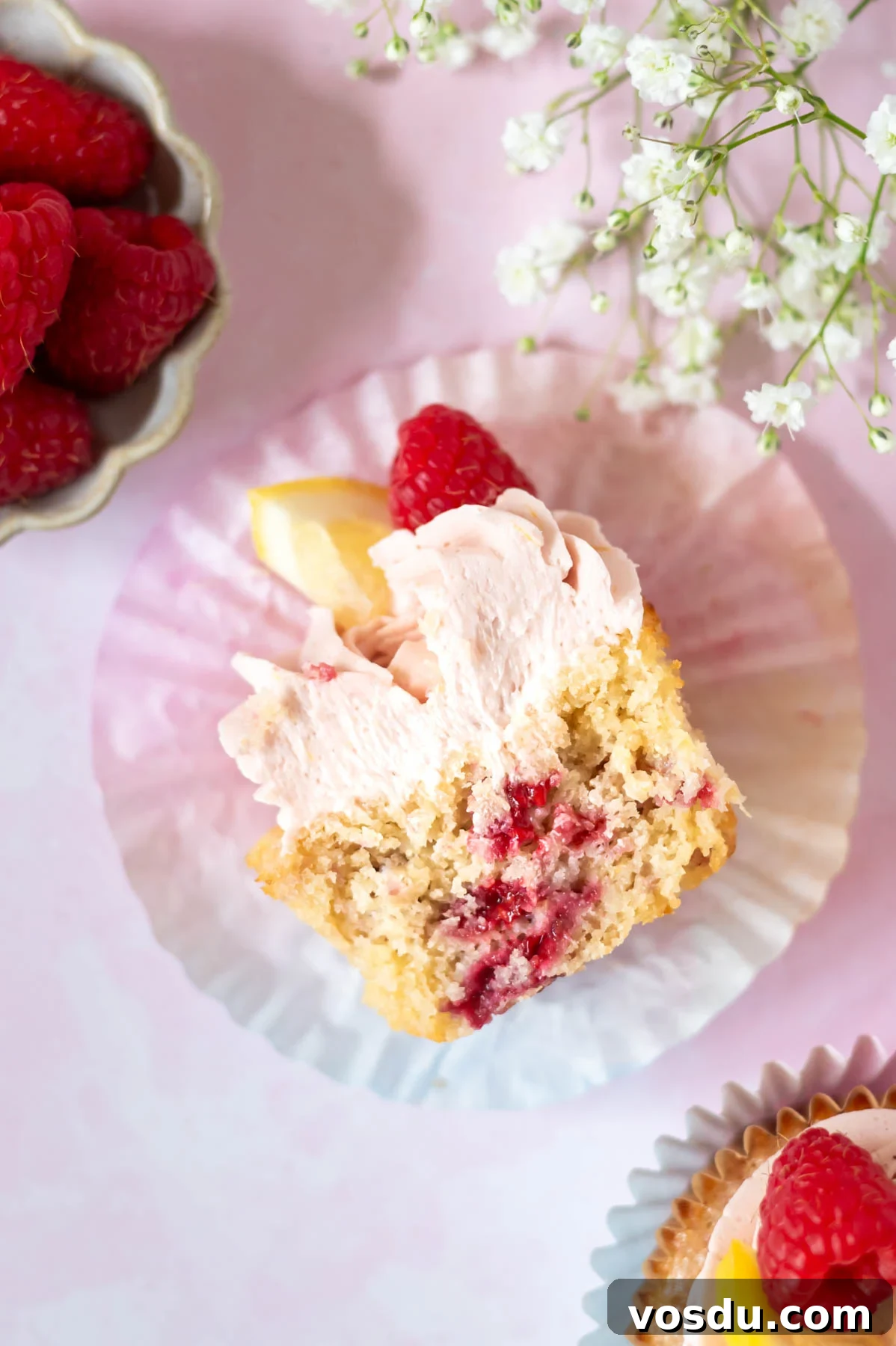 Lemon Raspberry Cupcakes Made from Scratch: Bright Citrus Dessert 2 lemon raspberry cupcake cut in half in a cupcake liner showing raspberries through the cupcake