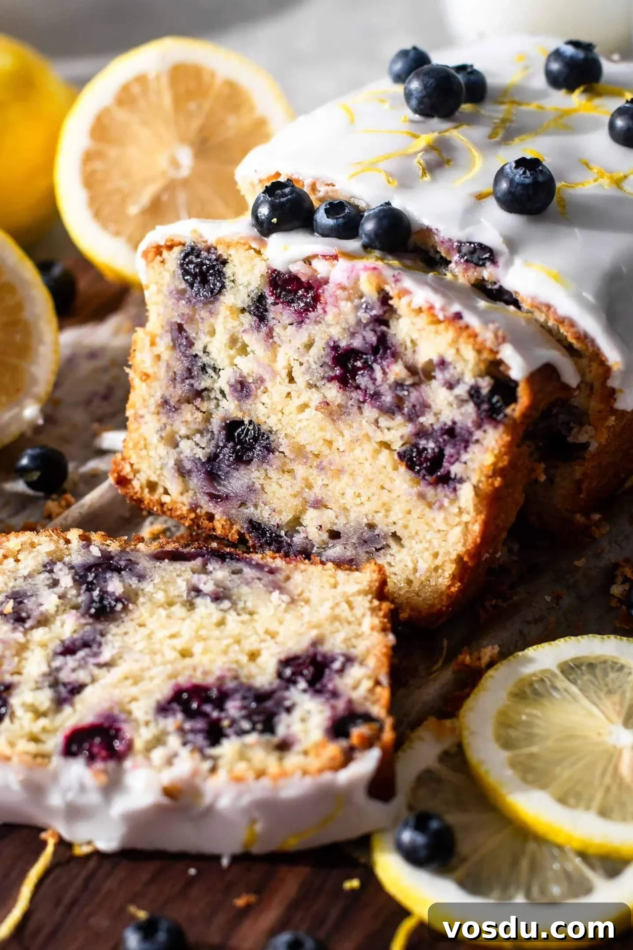 Lemon Blueberry Loaf Cake Recipe for Moist, Zesty Slices 2 sliced lemon blueberry quick bread on parchment lined wooden serving board