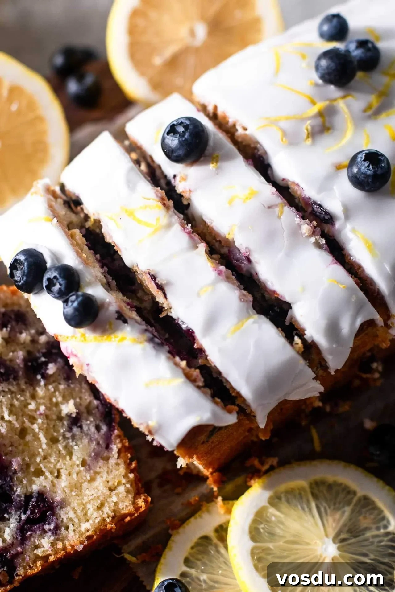 Lemon Blueberry Loaf Cake Recipe for Moist, Zesty Slices 3 sliced lemon blueberry quick bread on parchment lined wooden serving board-2