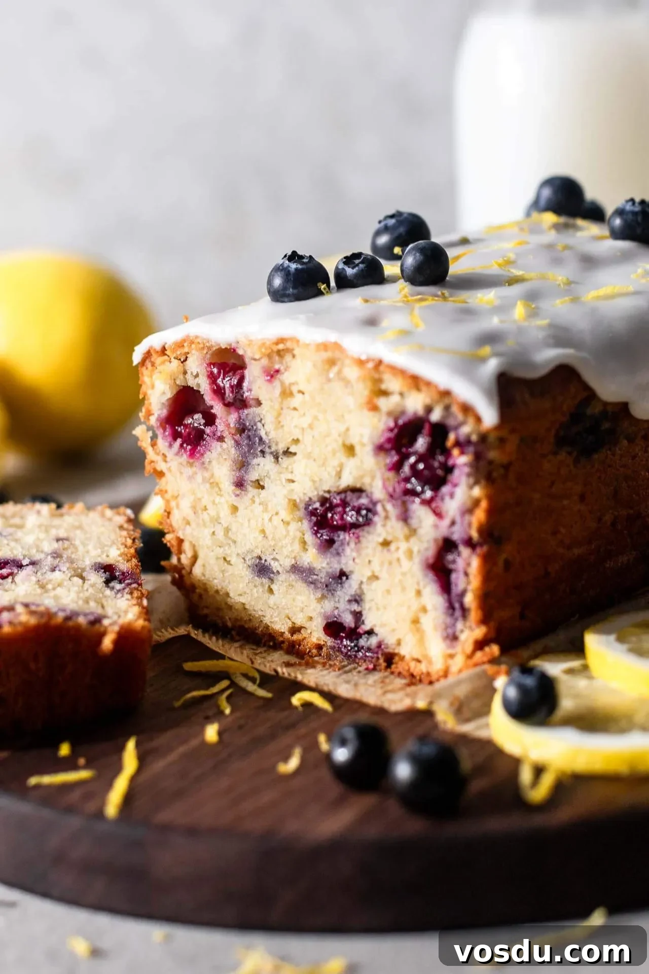 Lemon Blueberry Loaf Cake Recipe for Moist, Zesty Slices 10 sliced lemon blueberry quick bread on parchment lined wooden serving board-1