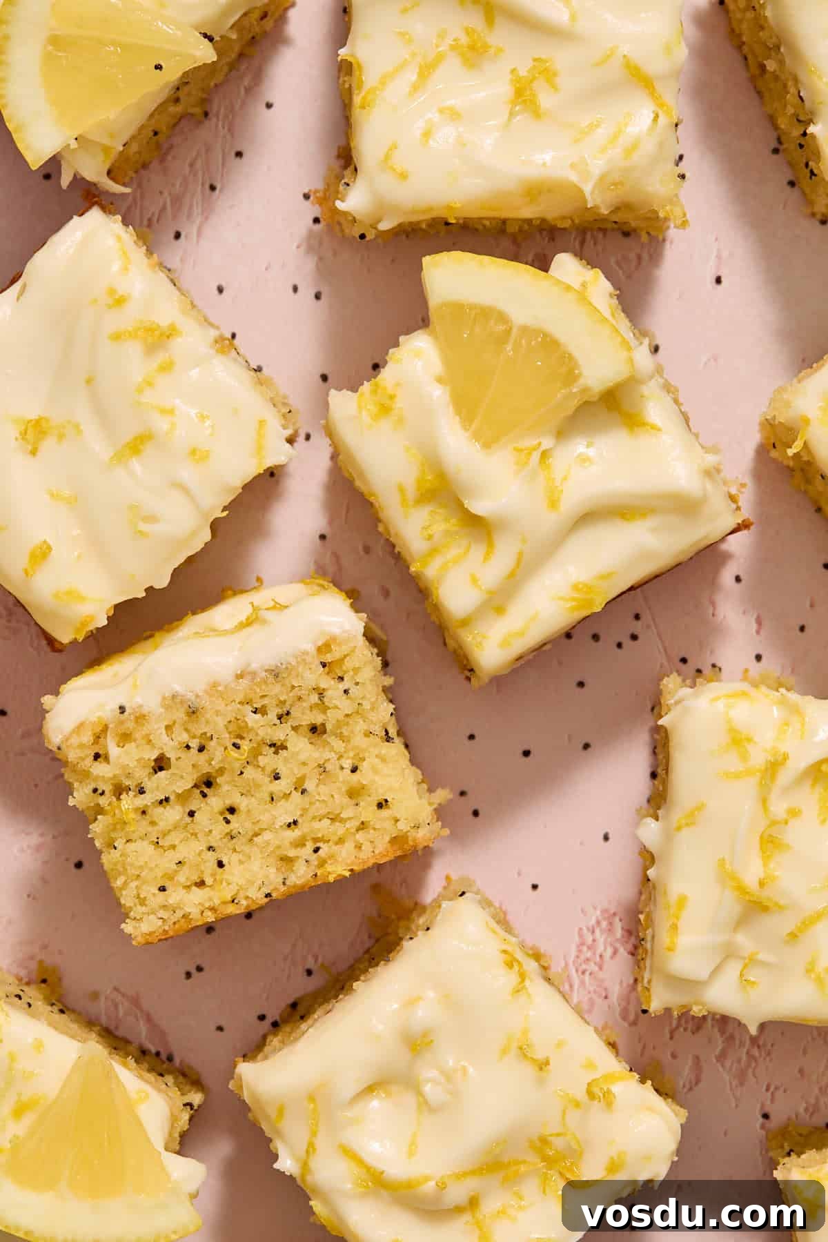 Almond Flour Lemon Poppy Seed Cake Recipe for Moist, Zesty Loaf 13 Pieces of cake arranged on a pink surface with one turned on its side.