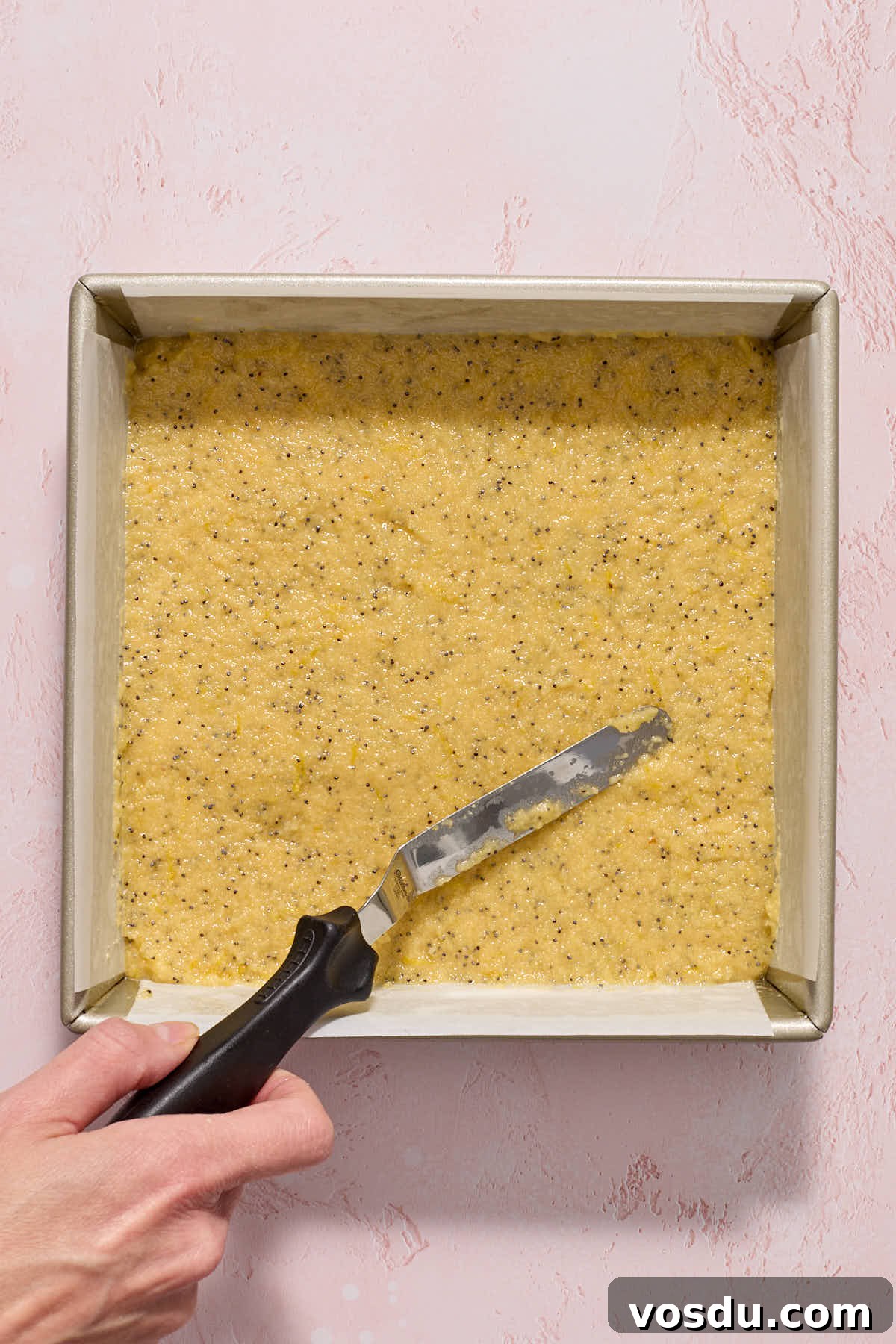 Almond Flour Lemon Poppy Seed Cake Recipe for Moist, Zesty Loaf 9 Batter spread out in a square pan with an offset spatula.