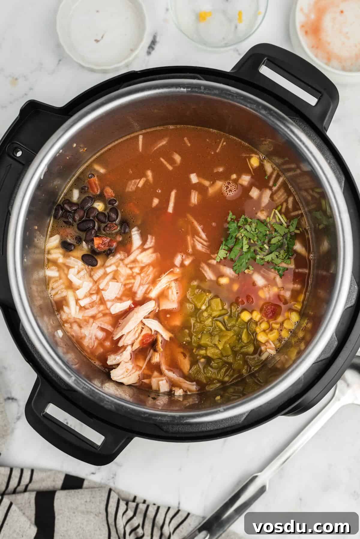 Slow Cooker Chicken Tortilla Soup Recipe — Comforting Weeknight Meal 4 Adding diced onion, corn, and beans into a slow cooker for chicken tortilla soup.