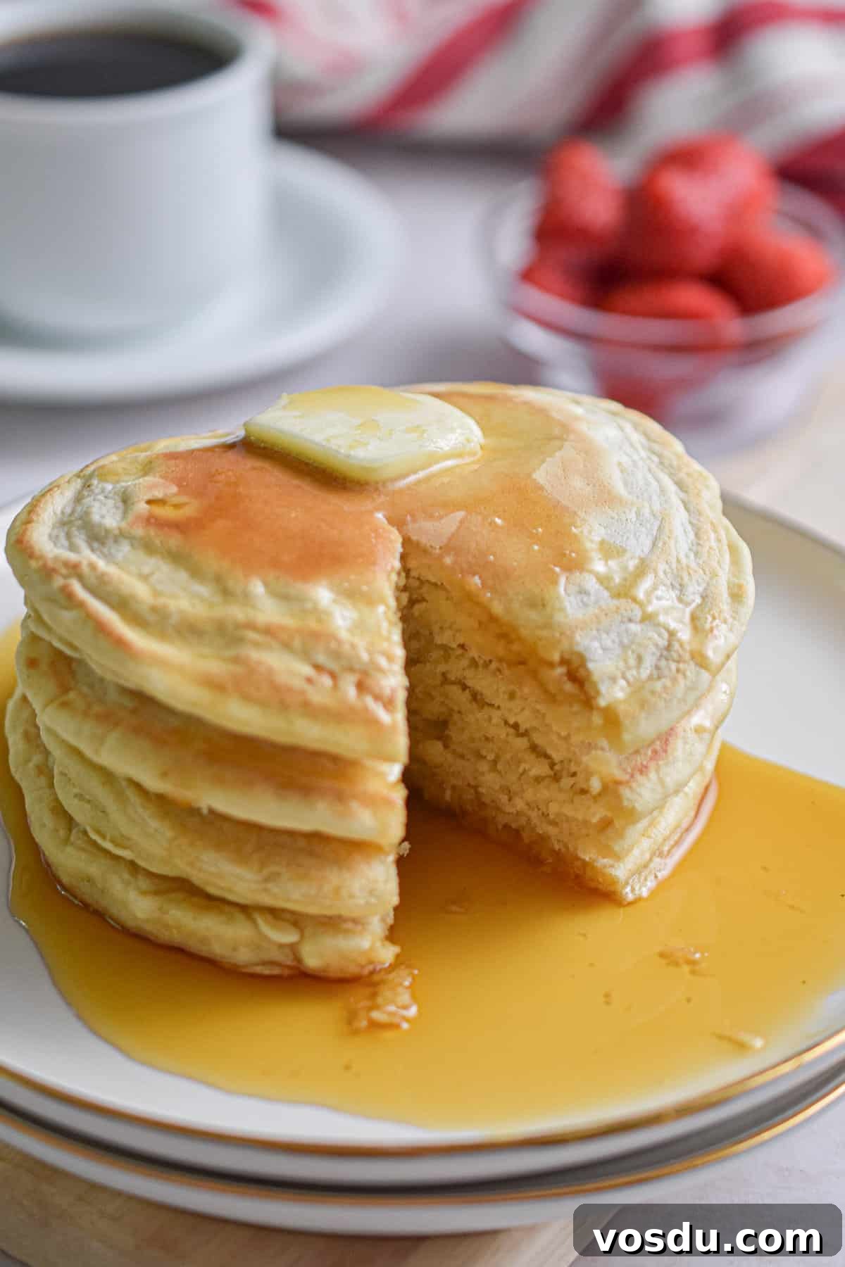 Fluffy Dairy-Free Pancakes Recipe for Breakfast and Brunch 11 A slice of the almond milk pancakes is cut out of the plate of pancakes.