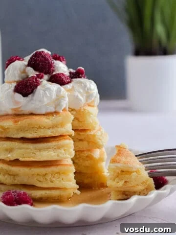 A fork is holding a piece of the stack of pancakes with self-rising flour.