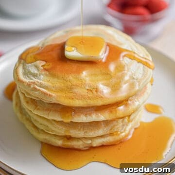 Fluffy Dairy-Free Pancakes Recipe for Breakfast and Brunch 16 Maple syrup is being drizzled over a stack of almond milk pancakes.