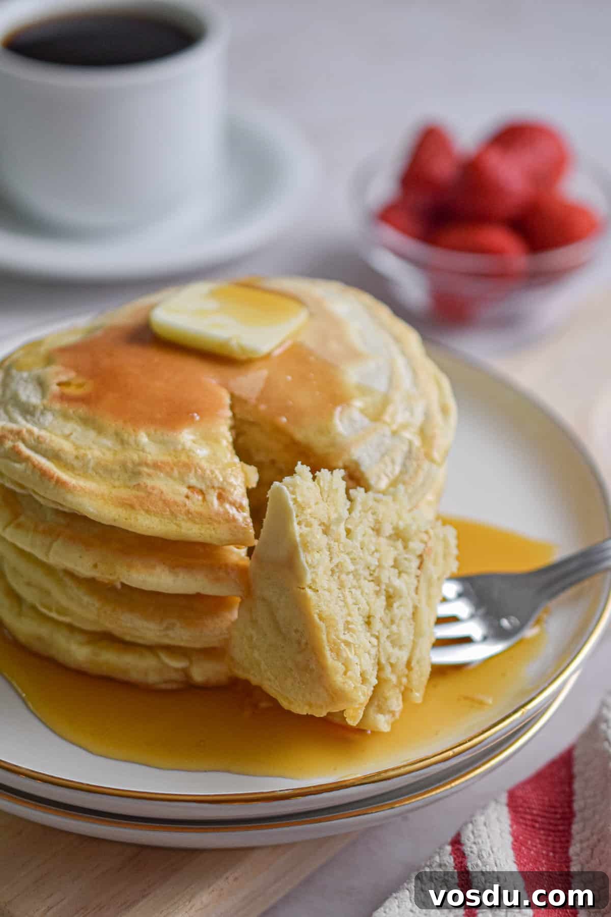 Fluffy Dairy-Free Pancakes Recipe for Breakfast and Brunch 10 A fork is holding a piece of the almond milk pancakes stack.
