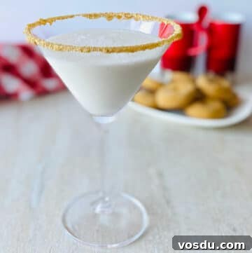 Gingerbread Martini Christmas Cocktail in martini glass with gingerbread cookies in the background