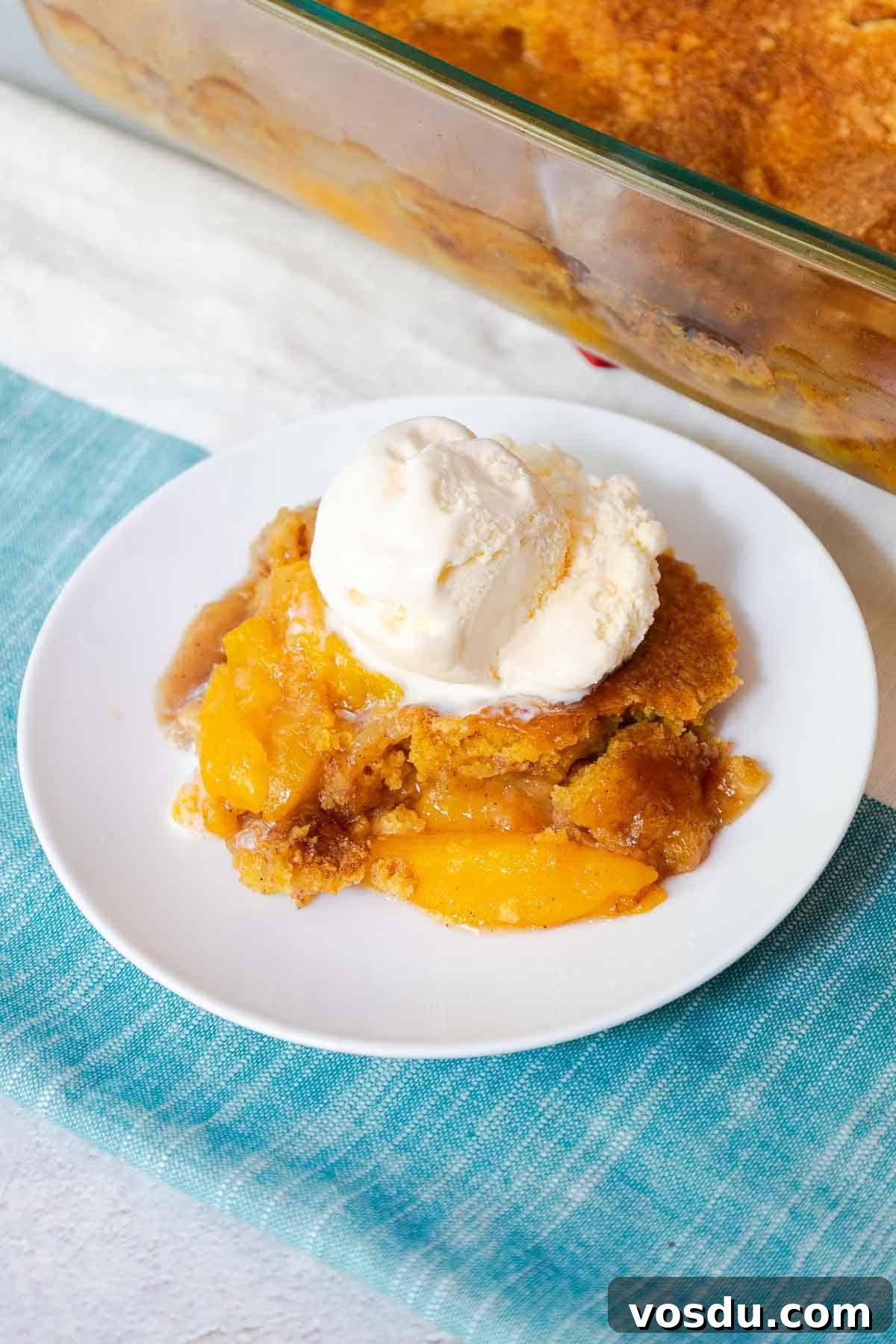 Quick Peach Cobbler Made with Cake Mix and Canned Peaches 2 Peach cobbler topped with a scoop of vanilla ice cream.