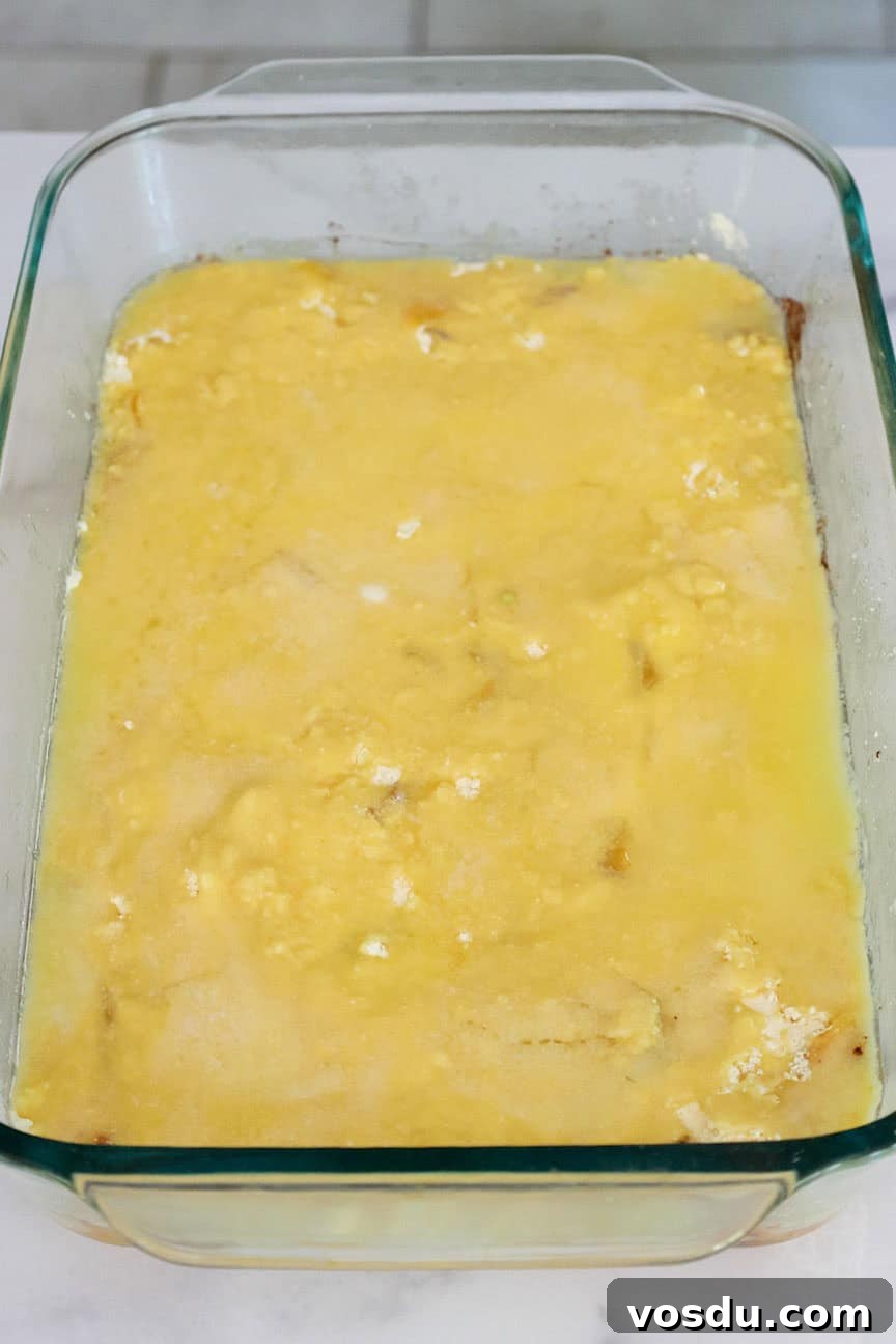 Quick Peach Cobbler Made with Cake Mix and Canned Peaches 7 Melted butter spread over the cake mix in a baking dish.