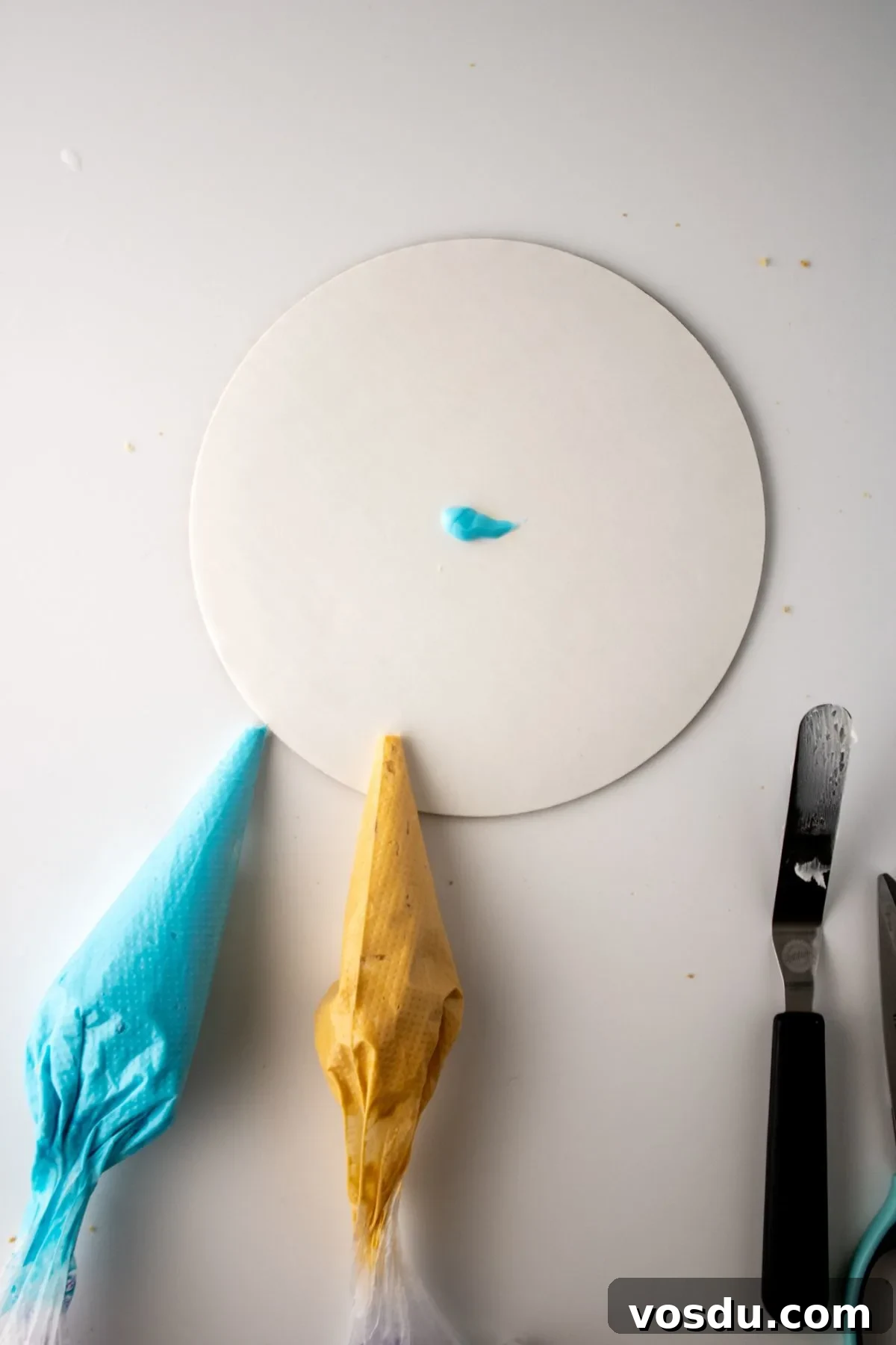 Bluey Cake Recipe with Simple Step-by-Step Tutorial 11 A dot of frosting on a cake board.