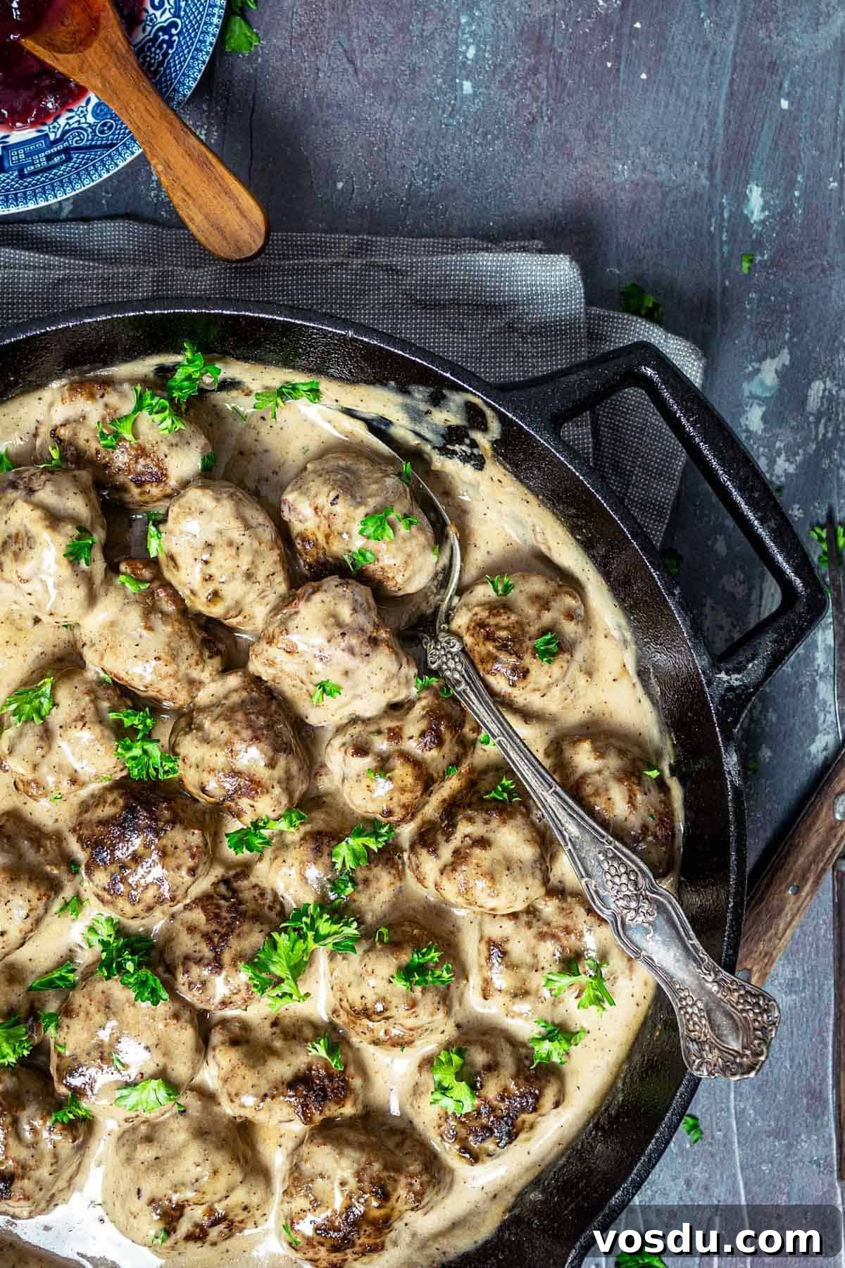 A close up of kӧttbullar in cream sauce with a spoon.