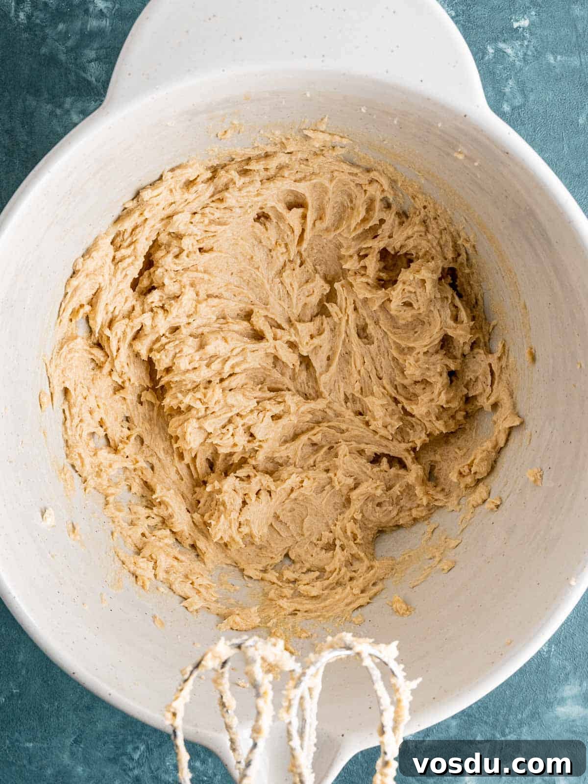Butter, sugars, egg, and vanilla extract mixed together in a bowl.