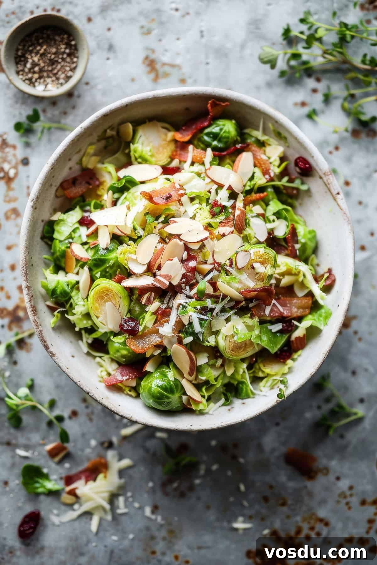 It's delicate shaved sprouts, warm and crispy bacon and bright citrus vinaigrette with toasted almonds. Shaved brussel sprout salad with bacon and vinaigrette.