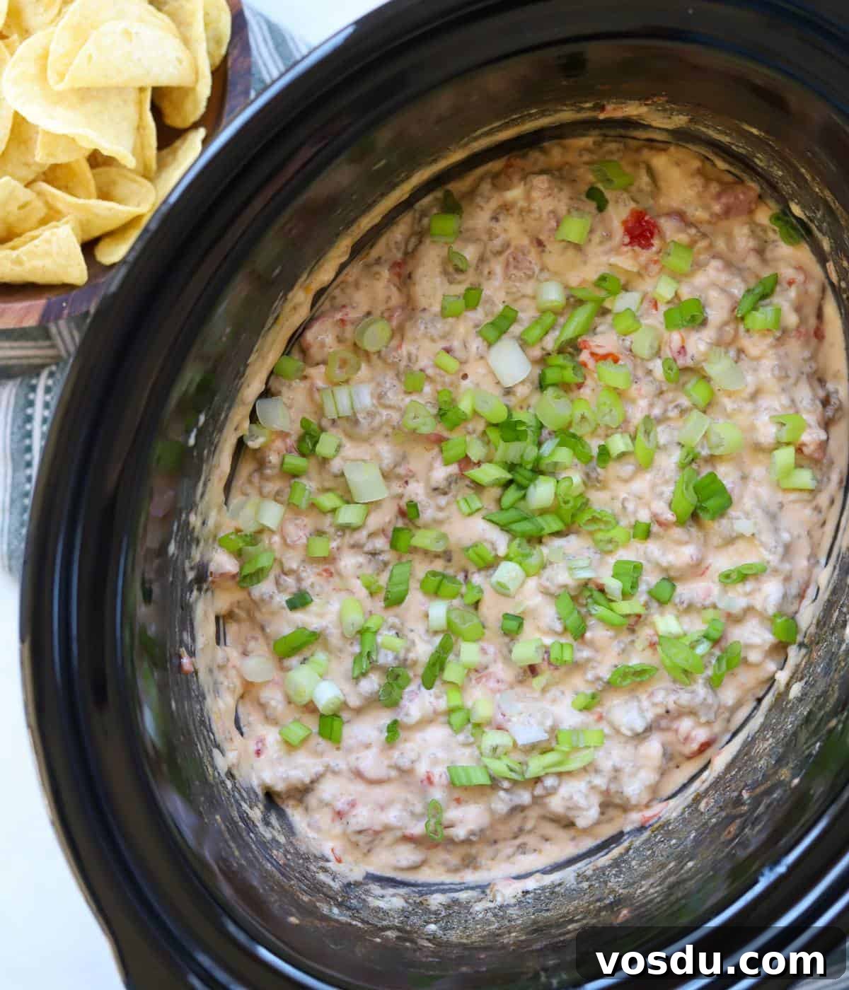 Creamy Rotel Sausage Dip (Slow Cooker Recipe) 7 Sausage rotel dip in slow cooker with chips.
