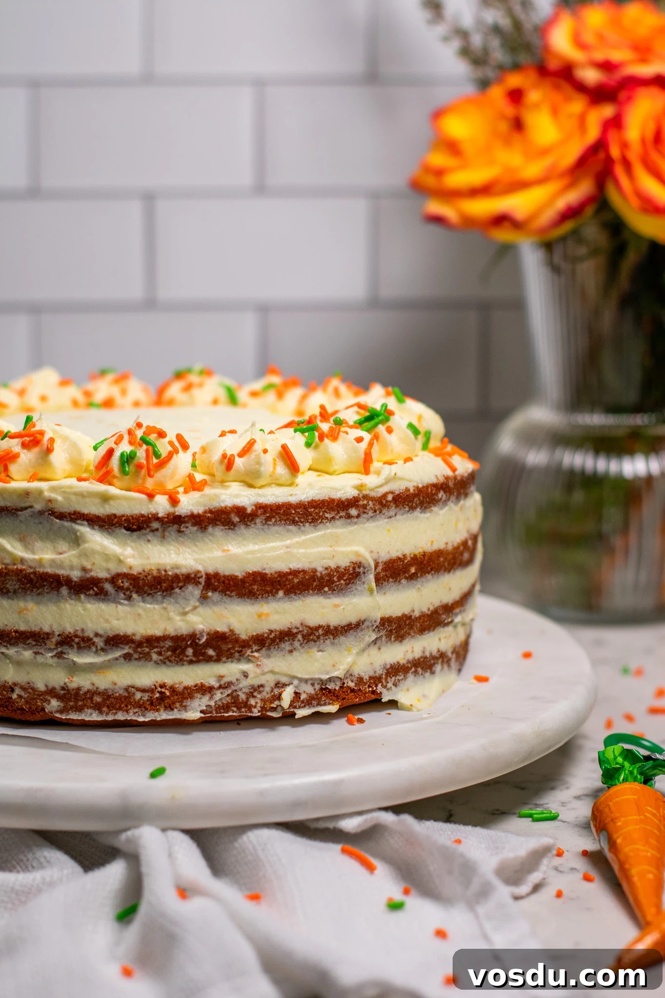 Classic Danish Carrot Cake Recipe with Cream Cheese Frosting 4 A carrot cake with cream cheese icing on a cake stand.