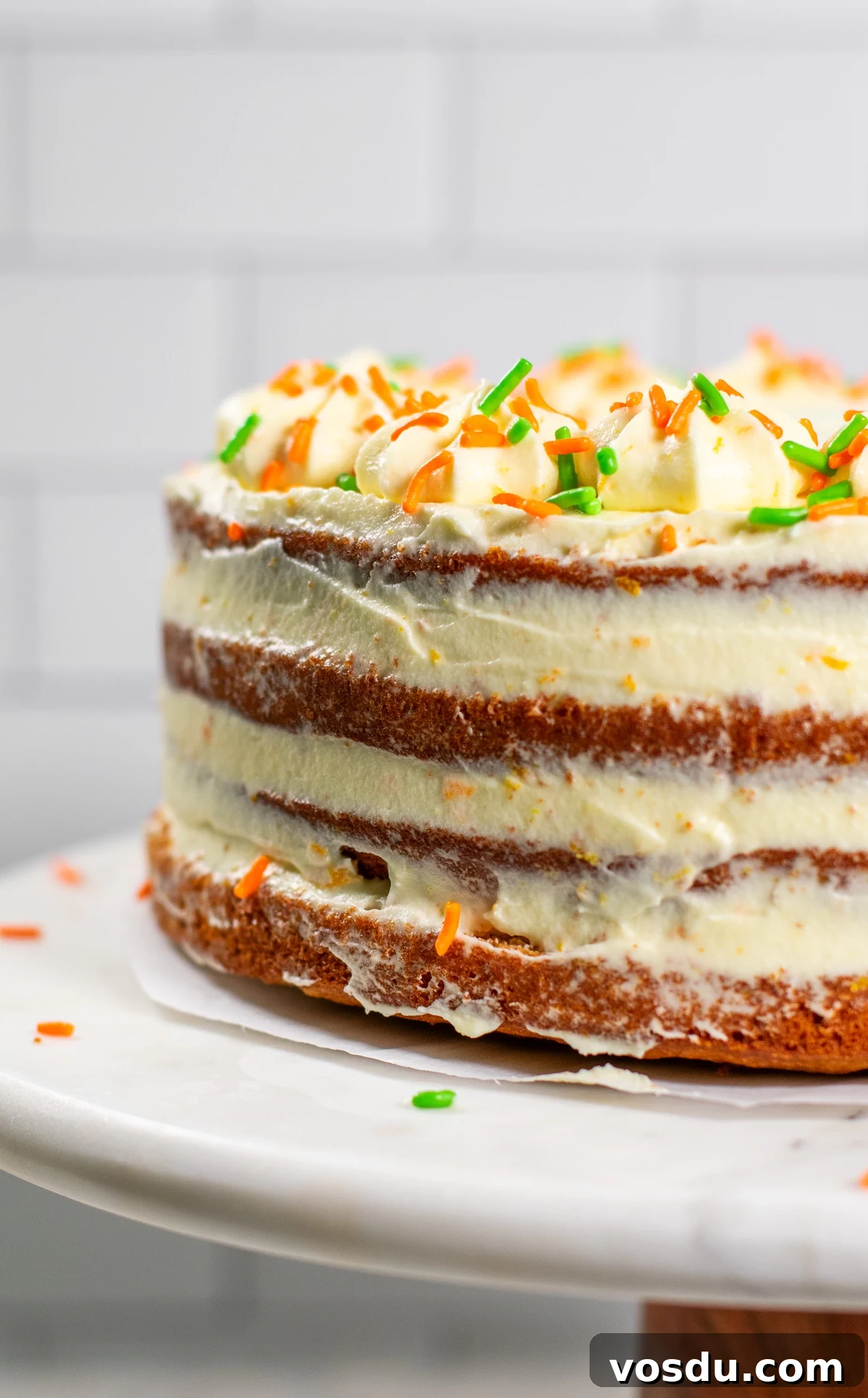 Classic Danish Carrot Cake Recipe with Cream Cheese Frosting 5 A carrot cake with cream cheese icing on a cake stand.