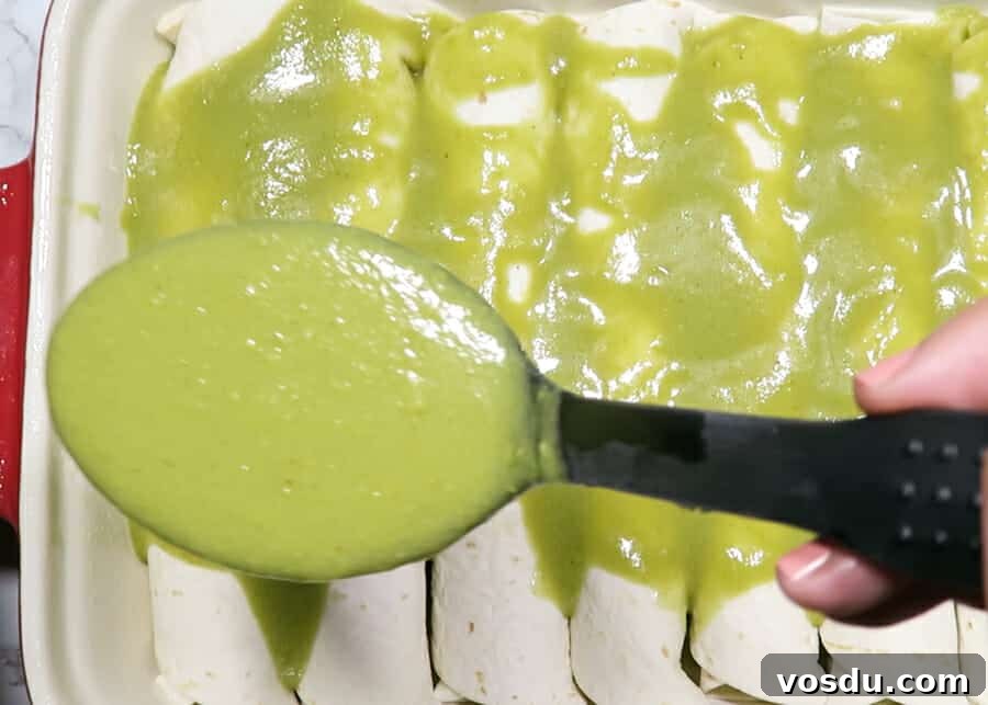 Chicken Enchiladas Verdes (Authentic Green Sauce Enchiladas) 7 pouring the green enchilada sauce over the enchiladas