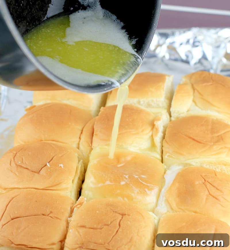 Maple Bacon Turkey Slakers on Hawaiian Rolls 9 butter being poured over the Hawaiian roll turkey sliders