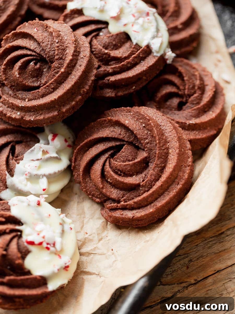 Gluten-Free Chocolate Butter Cookies Recipe for Rich, Crisp Cookies 2 gluten free chocolate butter cookies on parchment paper, some are dipped in white chocolate