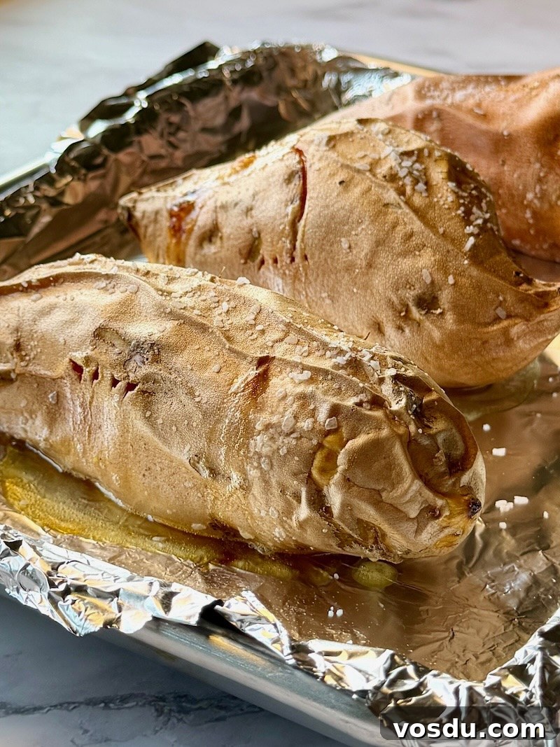 Taco-Stuffed Baked Sweet Potatoes — Savory Comfort Meal 5 Sweet potatoes baked on a sheet pan with olive oil and salt.