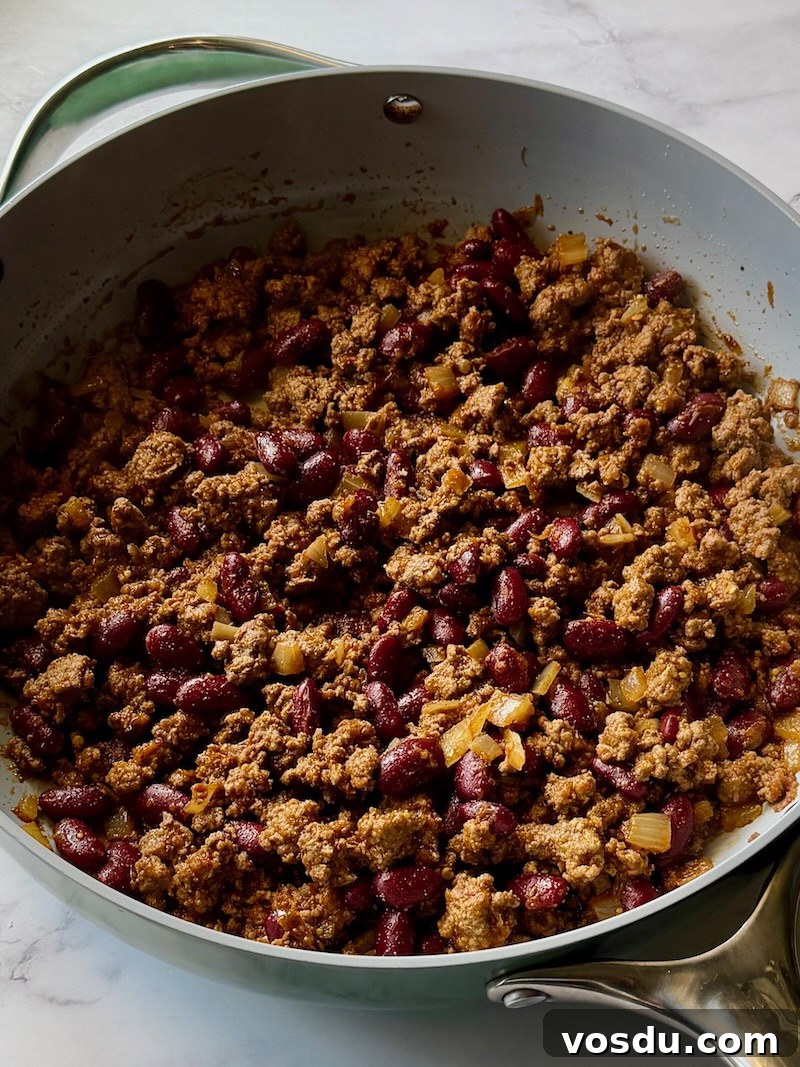 Taco-Stuffed Baked Sweet Potatoes — Savory Comfort Meal 7 Ground beef mixture cooked in a skillet with onions, beans, spices, and salsa.