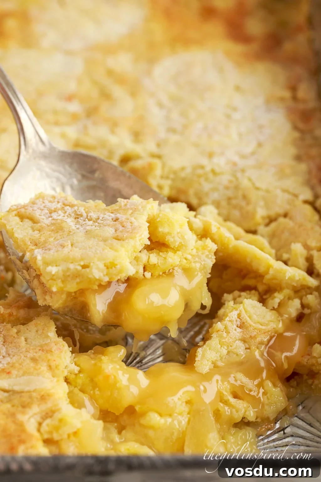 Tangy Lemon Pineapple Dump Cake Recipe for Summer Dessert 10 close up of a big spoon scooping out lemon pineapple dump cake